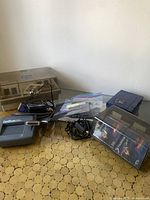 Photo showing the Iomega Zip Drive, CardScan 300X scanner, cables, adapter, and cassette tape storage box on patterned table.