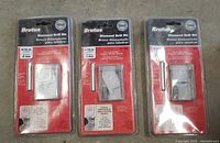 Three brand new Brutus 5/16 inch diamond drill bits in original packaging laid out on a surface.