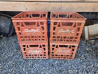 Front view showing 4 stacked red Sealtest milk crates with visible logos.
