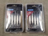 Two sealed packs of Amerock Cyprus cabinet handles, each pack containing 10 handles and hardware. Packaging shows product and branding.