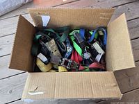 Box filled with multiple ratchet straps of various colors and condition