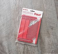 Freud BF3510 Universal Featherboard in original sealed plastic package on wooden surface.