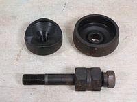 Green Lee SlugBuster manual knockout punch components including the punch, die, and draw stud laid out separately on a surface showing condition and parts.