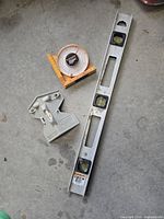 Top-down view of three levels including an aluminum spirit level, circular protractor level, and adjustable angle finder level tool