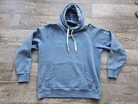 Full front view of Men's Under Armour Cold Gear hoodie in greyish-blue with drawstring hood and kangaroo pouch pocket.