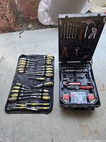 Two tool sets side by side on floor showing the screwdriver set spread out and the toolbox open.