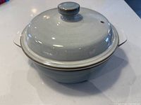 Top angled view of Denby Mist casserole dish with lid on, showing silvery blue glazed exterior and knobbed lid.