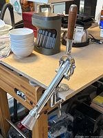 Overall view of chrome countertop wine opener mounted on tabletop