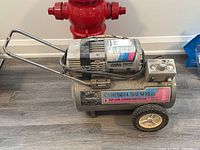 Full side view of Campbell Hausfeld 1HP PowerPal air compressor showing tank on wheels and handle.