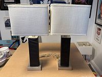 Pair of contemporary table lamps with rectangular black faux leather bases and white rectangular fabric shades, positioned side by side on a table.