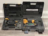 Both nailers open in their molded cases laid side by side.
