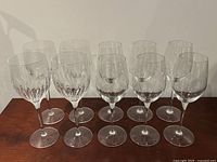 Front view of all 12 wine glasses, showing two distinct sets with patterned and smooth bowls.