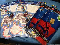 Five new sealed 3D activity placemats and puzzles, some with maze and dot-to-dot designs, others featuring Spider-Man theme, laid flat on blue surface.