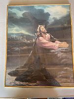 Frontal photo of a religious artwork showing Jesus praying, housed in a gold plastic frame on a flat surface.