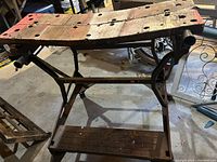 Photo showing entire Black and Decker Workmate woodworking bench with bent top and metal frame.