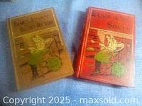 Photo showing two story books with illustrated covers, one brown and one red.