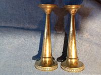 Front view of the two tall silver plate candle holders with tapered stems and round bases.