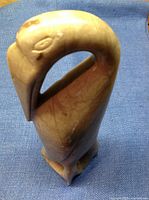 Front angled view of soap stone bird sculpture showing carved eye details and curved neck.