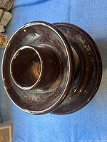 Top side view of brown ceramic electrical insulator showing glossy glaze and circular design.