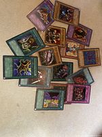 Photo showing a laminated spread of 15 Konami trading cards with varied designs and card types.