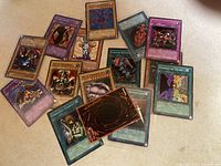 Photo showing 14 Yu-Gi-Oh! trading cards from Konami in good condition with various types such as monster, spell, and trap cards visible.