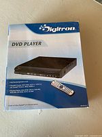 Box showing Digitron DVD player with image of player and remote on front, states playback format compatibility