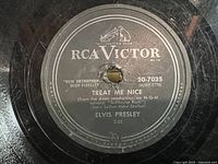 Close-up of RCA Victor record label for "Treat Me Nice" by Elvis Presley showing song title, catalog number 20-7035, and logo.