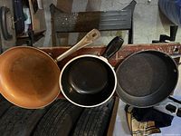 Top view showing three frying pans arranged side by side, displaying the interiors and handles.