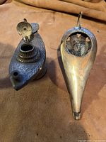 Top view of two old brass incense burners showing engraved patterns and heart-shaped cutouts