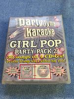 Front cover of Party Tyme Karaoke Girl Pop Party Pack 2 DVD with text showing 82 songs on 4 CDs with and without lead vocals, lyric booklets included and carrying case included.