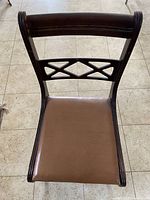 Top view of vintage wooden chair showing leather seat and decorative geometric backrest.