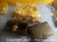 Black handbag, black address book, and leopard print slippers shown on carpeted floor.