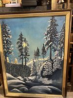 Framed oil painting 'Pines in Winter' showing pine trees in a snowy winter landscape with clear blue sky.