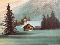 Close-up view of winter cabin scene oil painting on canvas.