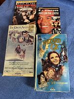 Four VHS tapes with original slip covers displayed on fabric background, titles visible
