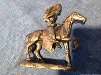 Side view of the solid pewter figurine showing detailed human figure in Native American attire mounted on horse with raised front leg.
