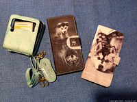 Image showing three phone cases: one green wallet-style with card slots and strap, and two folding folio-style cases with husky dog designs