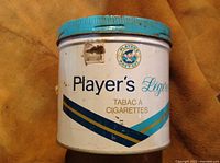 Front view of Player's Light cigarette tobacco tin can showing brand and navy cut emblem with text 'Tabac à Cigarettes'