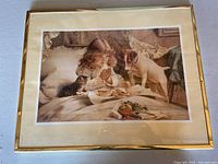 Photo showing prayer picture wall art with gold-colored frame, depicting a girl praying in bed with dog and cat.