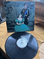 Photo of the front cover of the vinyl record album showing a painted portrait of Prince Charles and Lady Diana Spencer.