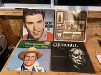 Front view of four vinyl record albums: Ricky Nelson, The Limelads, Gene Autry, and Winston Churchill tribute.