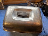 Top view of the aluminum roasting pan with fitted lid and handle.