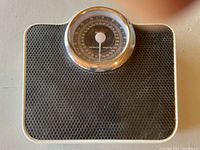 Photo of full mechanical scale showing black textured platform and circular dial with chrome bezel.