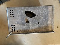 Top-down view showing the latch mechanism and ventilation holes of the steel animal trap.