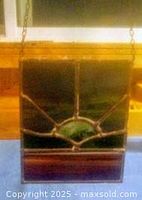 Close-up view of stained glass window sun catcher showing glass colors and metal leading design