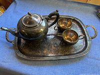 Silver plate tea set with teapot, creamer, sugar bowl arranged on the large rectangular tray showing overall setup.