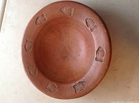 Top view showing the inside of the terracotta bowl with embossed fish designs around the inner rim.