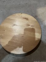 Top view of round wooden turn table surface showing natural wood grain and knots.