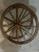 Top view of wooden antique wagon wheel showing segmented rim and spokes.