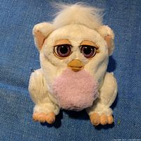 Front view of the vintage white and pink Furby plush toy showing its detailed facial features and overall condition.